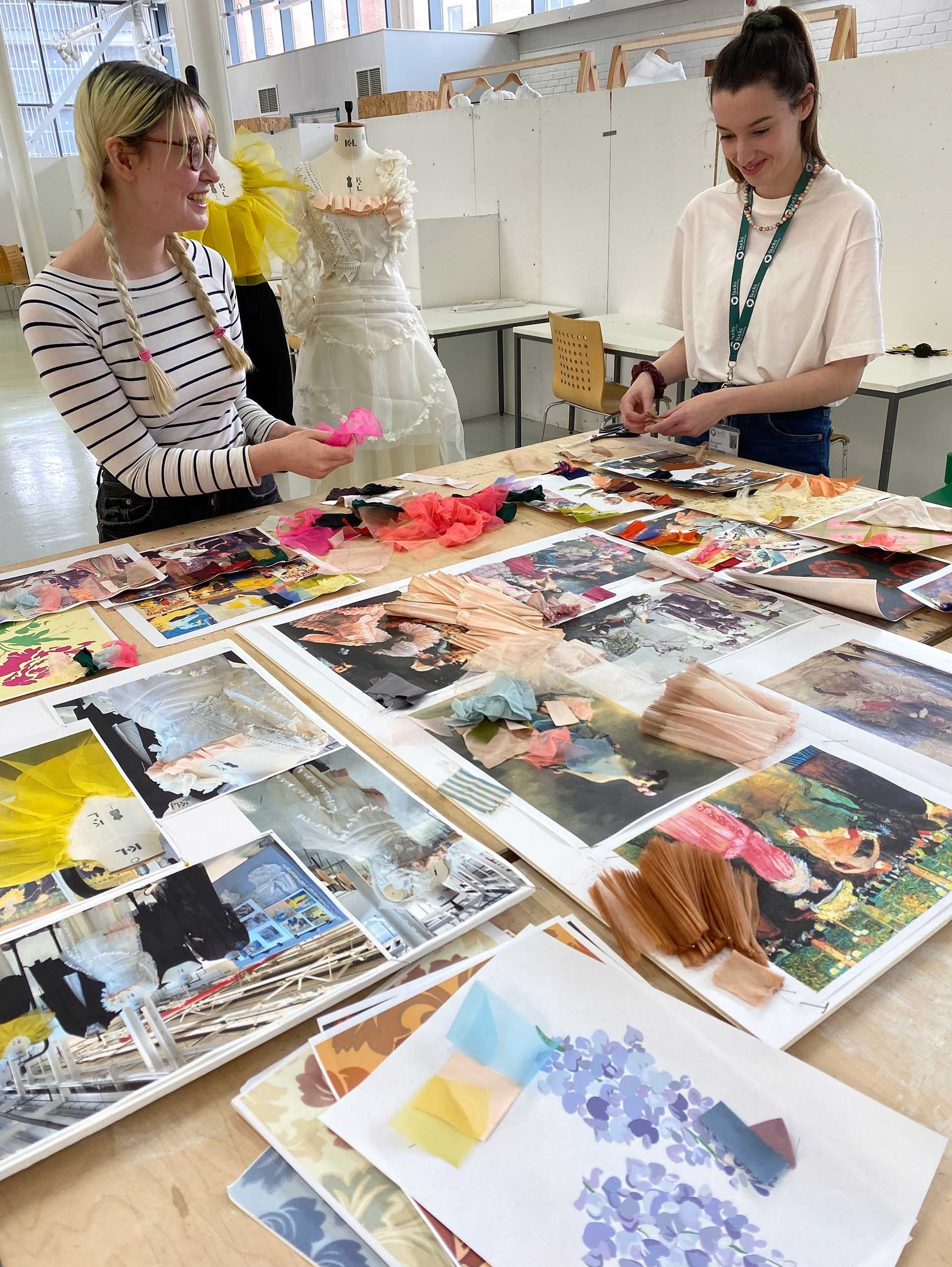 Students with fabrics and ideas spread out round them 