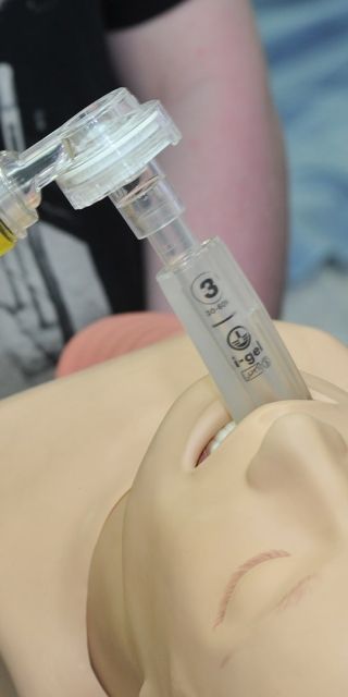 Nursing students attend to a dummy person, giving them oxygen 