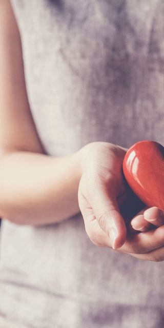 Female holding heart to show health and wellbeing