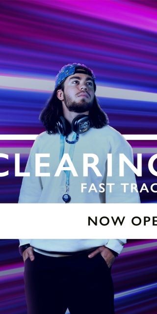 Man wearing headphones in front of neon lights with a 'Clearing Fast Track Now Open' sign