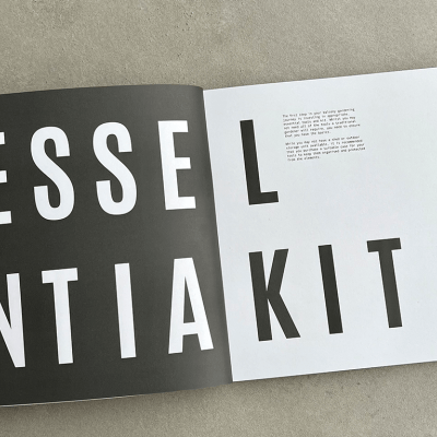 An open squared book with text which reads "Essential Kit".