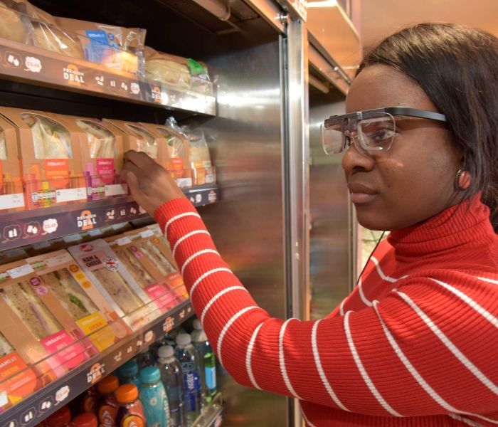 Female student wearing eye tracker and looking at food counter