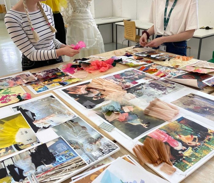 Students with fabrics and ideas spread out round them 