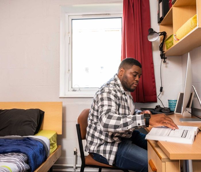 A student working at his desk in a Brook Street bedroom