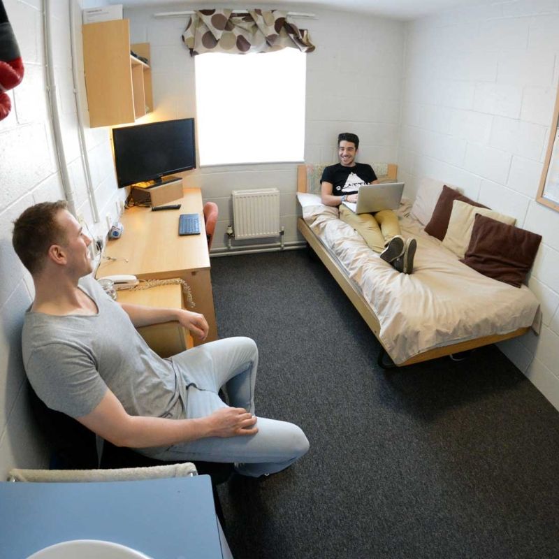 two students sitting and chatting in a standard room in Brook Street accommodation