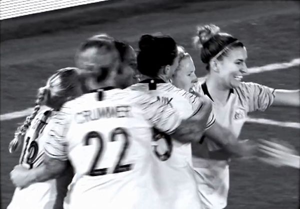 A group of female footballers celebrating scoring a goal