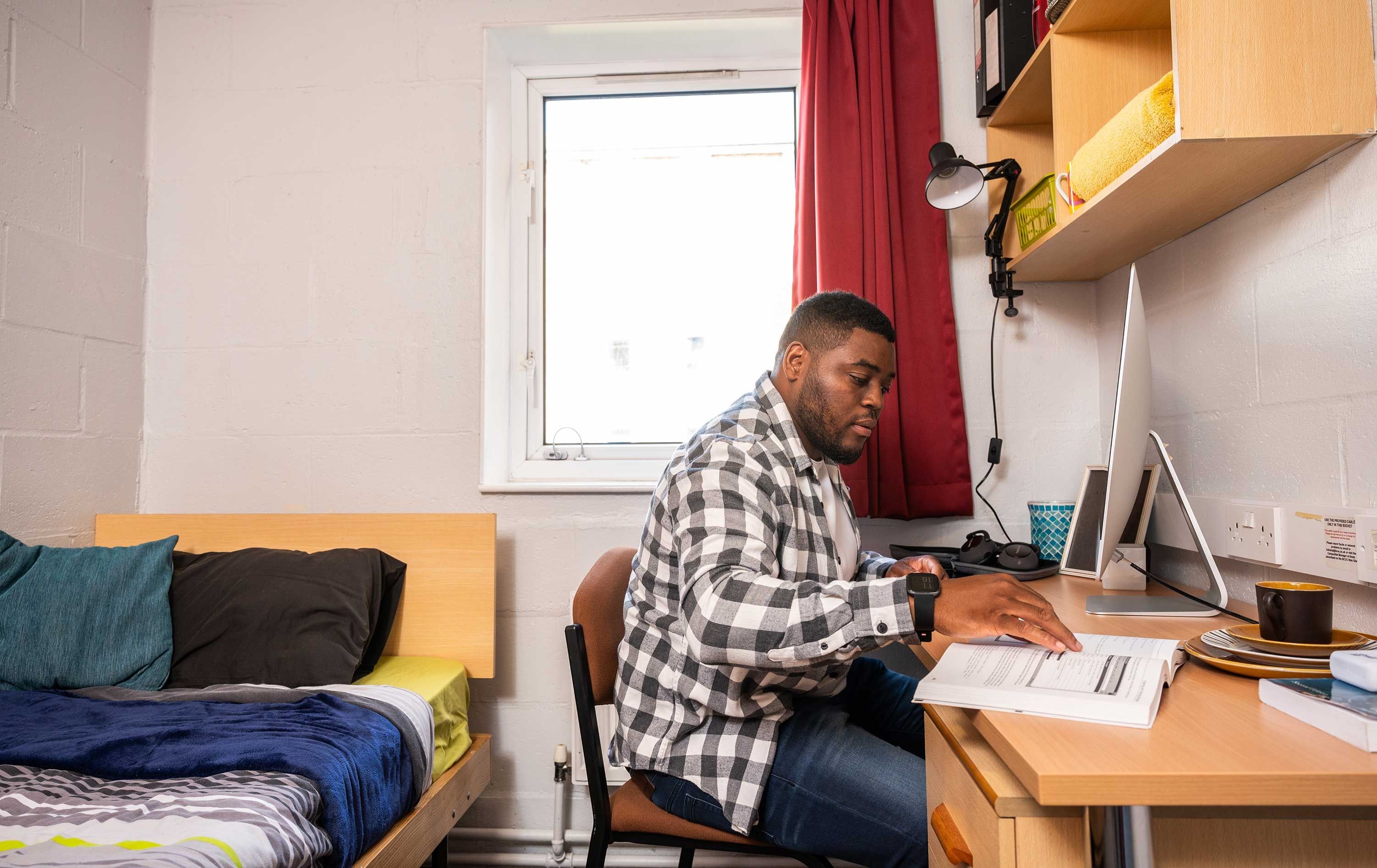 A student working at his desk in a Brook Street bedroom