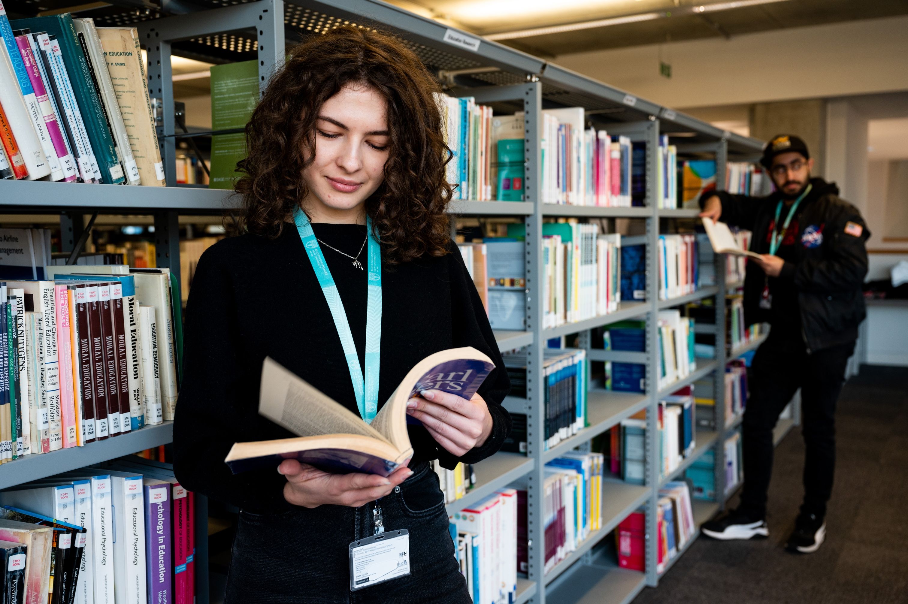 female student in library looking at books